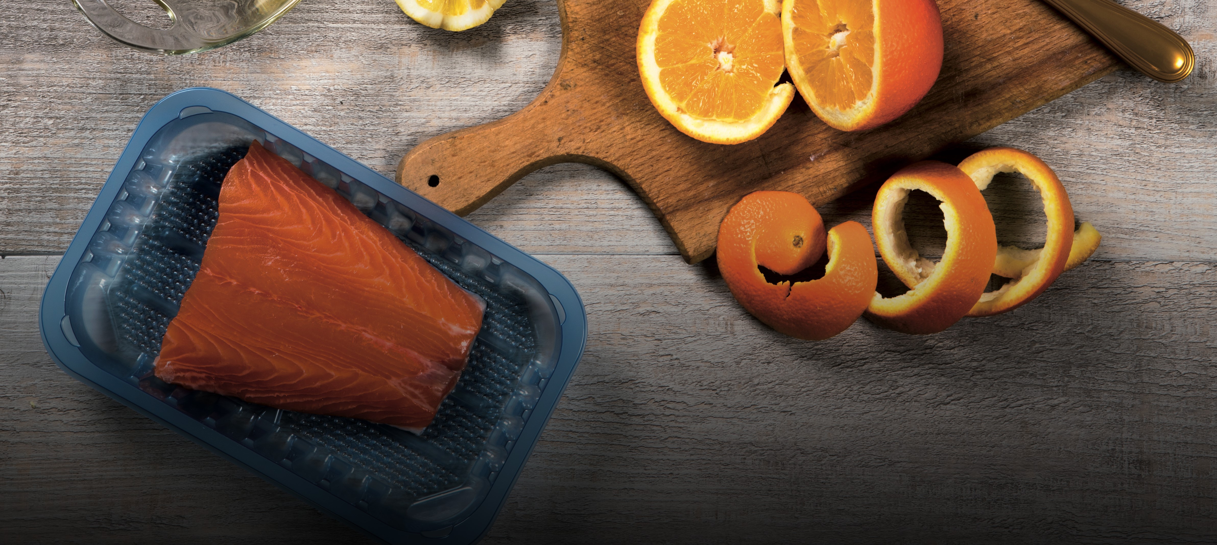 Arance e salmone su una vaschetta blu semitrasparente